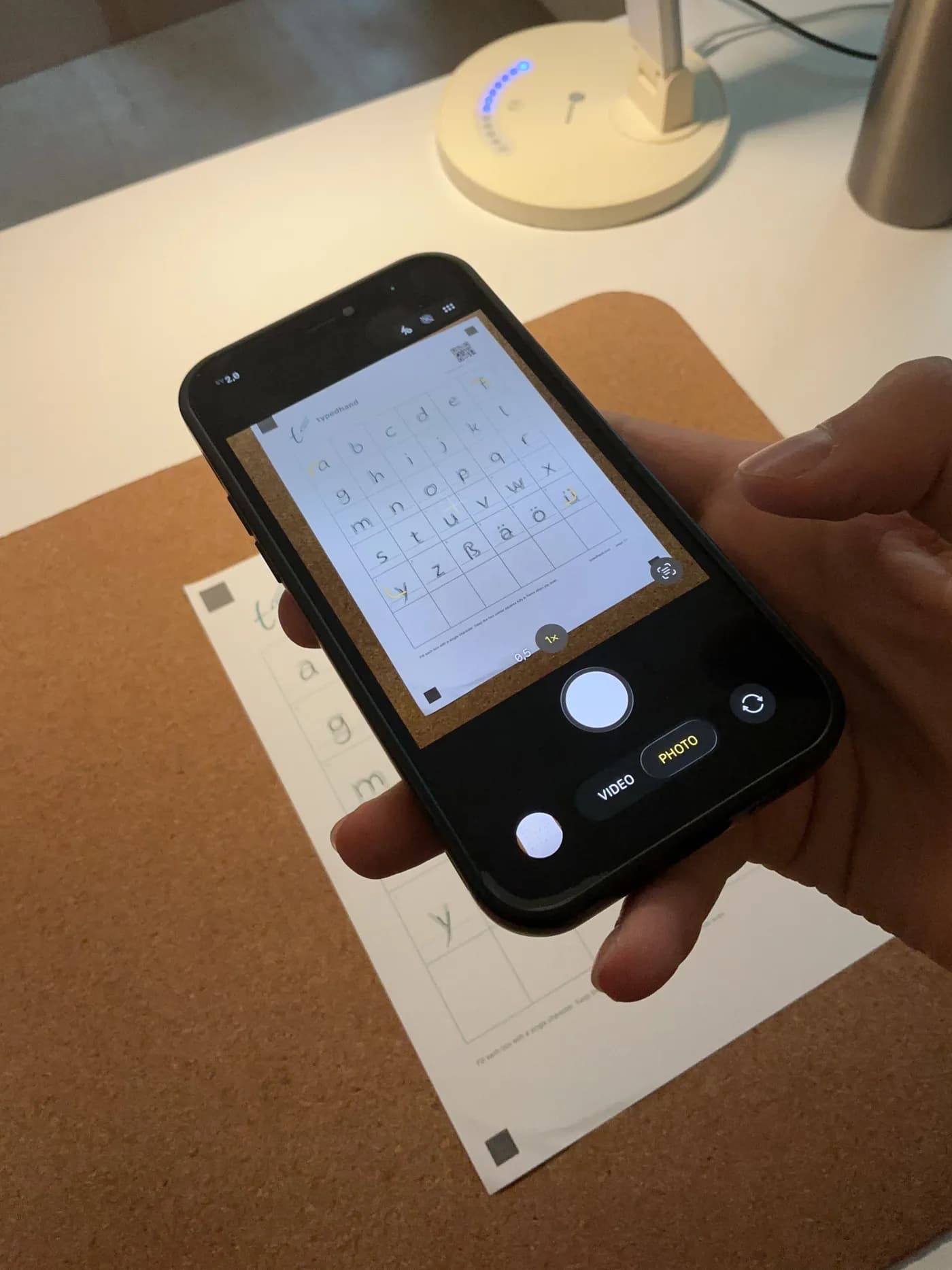 A phone photographing the hand-filled TypedHand template on a desk β no tablet, no stylus.